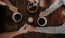 people holding hands on table holding coffee