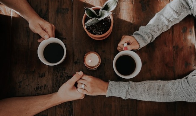 Everything In Reach people holding hands on table holding coffee